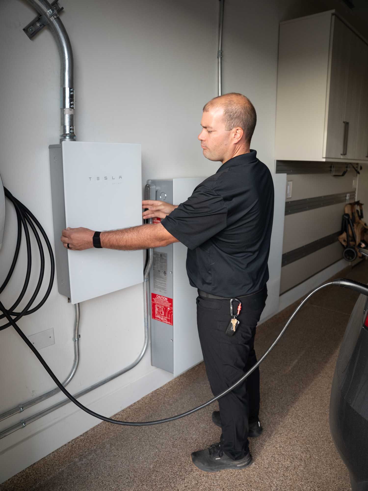 Scheid Electric electrician Collin working inside an electrical panel during a Tesla Powerwall installation